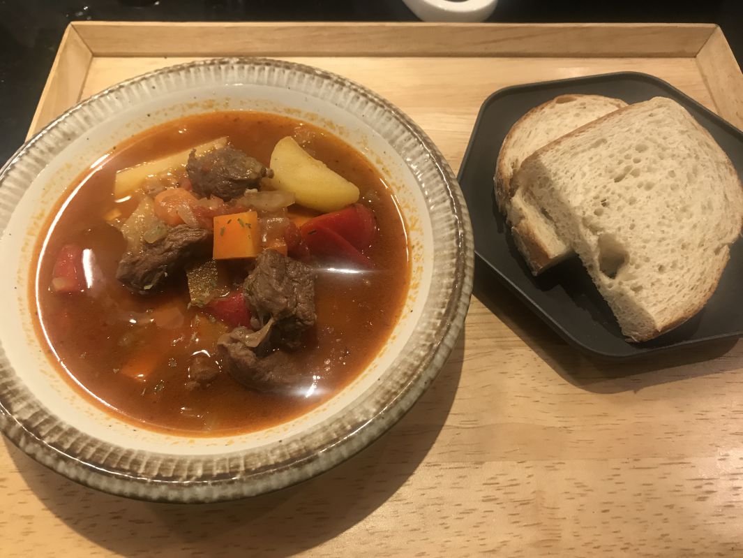 グヤーシュとパンの提供の写真。